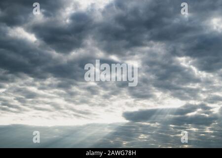 Sunlight shines through the cloudy sky. stormy sky with sunbeam. overcast weather Stock Photo