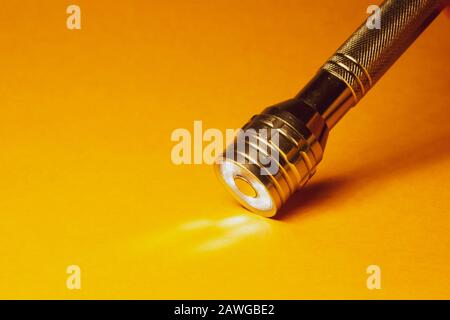 Metal flashlight on a yellow background Stock Photo
