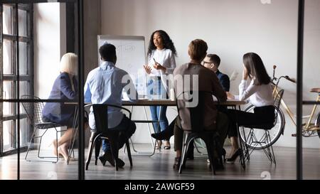 Diverse workers listening african businesswoman tell about strategy at meeting Stock Photo