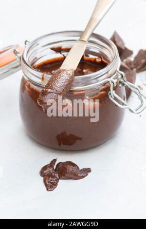 Homemade vegan hazelnut chocolate spread on a knife and in a kilner jar Stock Photo