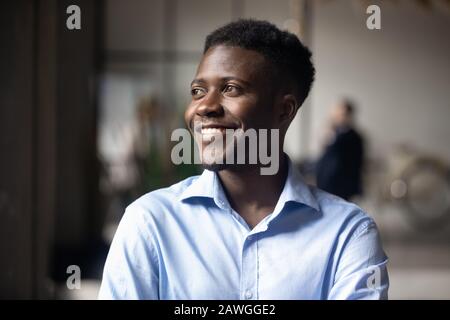 Happy African ethnicity businessman standing in modern workspace feels satisfied Stock Photo