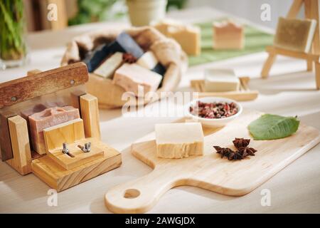 Dried rose buds, leaves and badian flowers for making soap bars on table in workshop Stock Photo