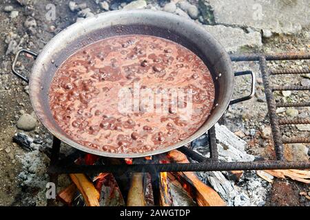 Close-up of a pork blood stew boiling in a a wok frying pan on a traditional fire place, called dirty kitchen, in a philippine home Stock Photo