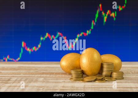 golden eggs,coins,banknote with the stock graph background. selective focus Stock Photo