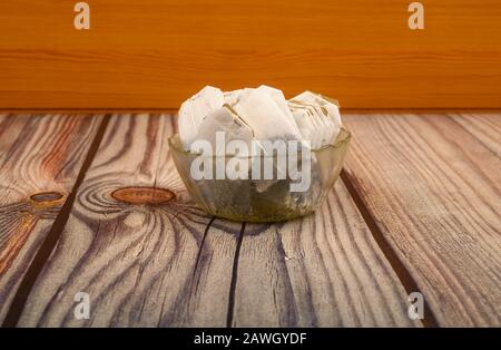 Tea bags in a glass vase on a wooden background. Close up Stock Photo