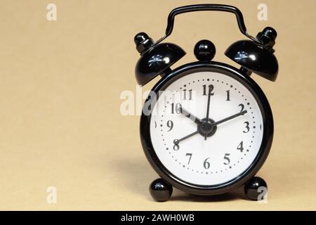 Classic alarm clock on light pastel background. vintage watch with round dial. copy space Stock Photo