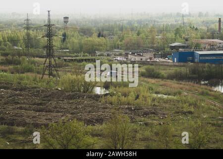 Truck car among forest near the factory. power lines. manufacture building. railway in marshland. aerial view