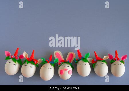 top view flat lay frame of easter eggs unicorns and rabbit on a gray background with  place for text Stock Photo