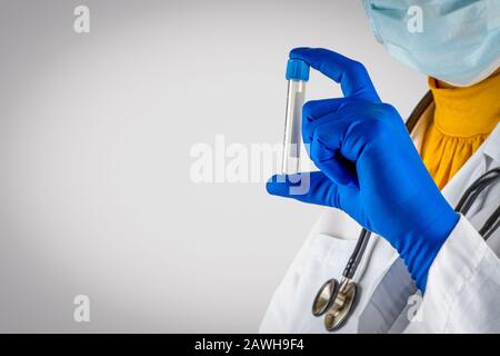 Stethoscope and doctor hands holding specimen bottle on white background. Selective focus and crop fragment Stock Photo