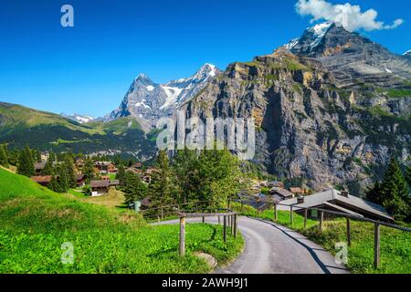 Majestic mountain resort with alpine wooden houses and high snowy mountains in background, Murren, Bernese Oberland, Switzerland, Europe Stock Photo