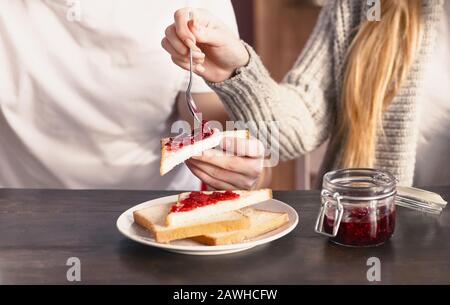 Unrecognizable couple having american breakfast sandwiches, close up Stock Photo