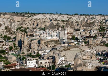 The village of Goreme in the Cappadocia region of Turkey where modern buildings sit adjacent to ancient volcanic rock fairy chimneys. Stock Photo