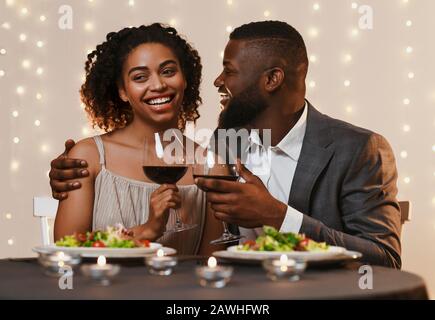 Young afro man and woman having dinner in restaurant Stock Photo