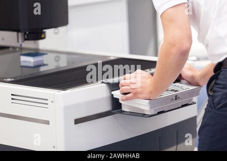 Technician is using joystick and keyboard to operate electronic device Stock Photo