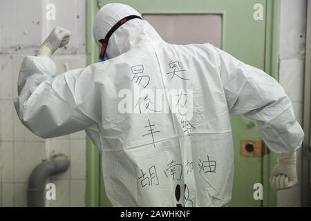 (200209) -- CHANGSHA, Feb. 9, 2020 (Xinhua) -- Yi Junfeng displays handwritings on his protective suit in support of the battle against the novel coronavirus outbreak, at Hunan People's Hospital in Changsha, central China's Hunan Province, Feb. 7, 2020. Amid the current novel coronavirus outbreak, 22-year-old male nurse Yi Junfeng has volunteered to join the battle against the epidemic. After a series of professional trainings, he now works as a front-line fever clinic nurse at Hunan People's Hospital in Changsha. Yi believes that a male nurse has comparative advantages in terms of physical st Stock Photo