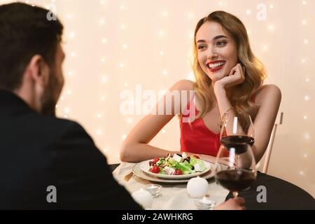 Young couple at restaurant having romantic dinner, enjoying time together Stock Photo