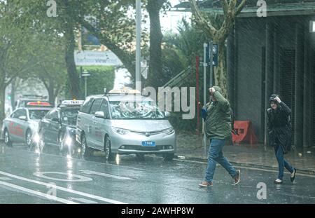 Sydney, Australia. 9th Feb, 2020. People walk in the rain in Sydney, Australia, on Feb. 9, 2020. A huge rainfall hits Australia's bushfire-ravaged east coast on Friday. In the midst of the worst drought on record, the huge rainfall on Friday is predicted to stick around for at least a week and may bring relief to the long-suffering communities. Although the rain is mostly being seen as good news, authorities are also warning that fire-damaged areas are at extreme risk of flooding. Credit: Bai Xuefei/Xinhua/Alamy Live News Stock Photo