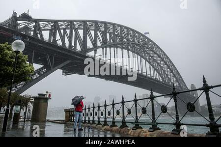 Sydney, Australia. 9th Feb, 2020. A citizen walks in the rain in Sydney, Australia, on Feb. 9, 2020. A huge rainfall hits Australia's bushfire-ravaged east coast on Friday. In the midst of the worst drought on record, the huge rainfall on Friday is predicted to stick around for at least a week and may bring relief to the long-suffering communities. Although the rain is mostly being seen as good news, authorities are also warning that fire-damaged areas are at extreme risk of flooding. Credit: Bai Xuefei/Xinhua/Alamy Live News Stock Photo