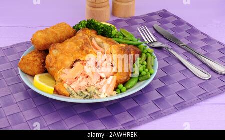 Pink salmon wrapped in puff pastry meal with potato croquettes and vegetables Stock Photo