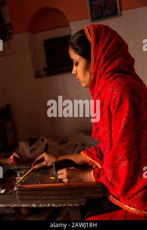 India, Rajasthan, Shekhawati, Nawalgarh, making traditional lac bangles by hand, young woman forming hot bangle into shape Stock Photo