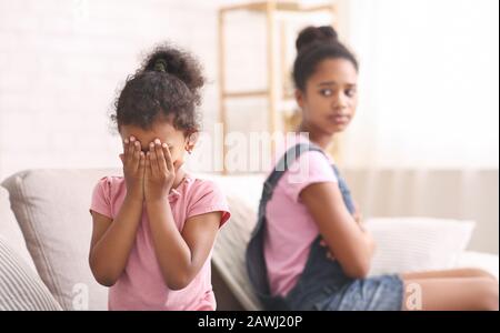 Little african girl crying at home, being offended by her sis Stock Photo