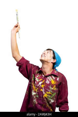 Smiling young painter artist pointing upwards Stock Photo