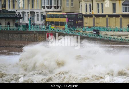 Brighton UK 9th February 2020 - A bus passes by as waves crash on to Brighton seafront  as Storm Ciara hits Britain with amber warnings being given throughout the country as high winds are expected to cause damage and possible danger to life: Credit Simon Dack / Alamy Live News Stock Photo