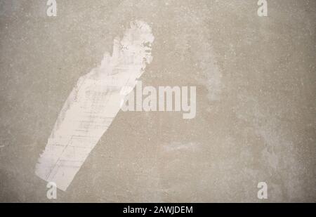 Cement rough gray wall during building process with white line of paint or plaster. White stroke on gray concrete background. Stock Photo