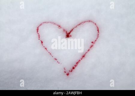 Red heart painted with red paint on snow symbol of love postcard for Valentines Day. Stock Photo