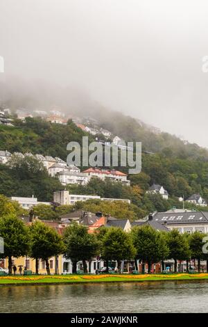 Editorial 09.04.2019 Bergen Norway Hillside homes at Floyfjellet on a rainy and partly foggy so that the top is not visible on an autumn day Stock Photo