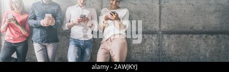 Group of multiracial students and friends watching smart mobile phones. New technology trend. Stock Photo
