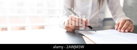 Business woman signing contract document on office desk, making a deal. Stock Photo