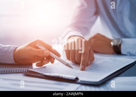 Business people negotiating a contract. Human hands working with documents at desk and signing contract. Stock Photo