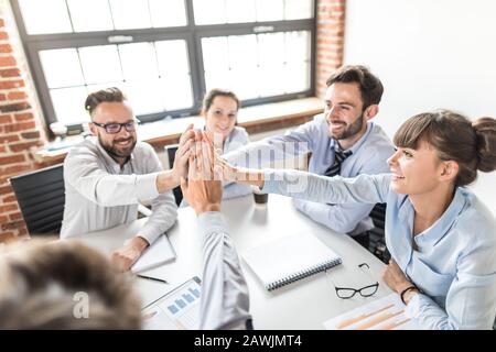 Business people happy showing team work and giving five in office. Teamwork concepts. Stock Photo