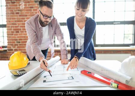 Architects working with blueprints in the office. Teamwork architects concept. Stock Photo