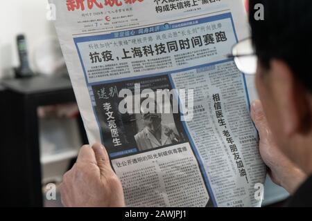 A local Chinese resident reads reports mourning Chinese doctor and coronavirus whistleblower Li Wenliang after he died from the new coronavirus and pn Stock Photo