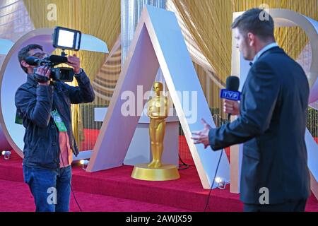 (200209) -- LOS ANGELES, Feb. 9, 2020 (Xinhua) -- Media reporters work in front of the characters of Oscars out of Dolby Theater during the preparations for the 92nd Academy Awards in Hollywood, Los Angeles, the United States, on Feb. 8, 2020. (Xinhua/Li Rui) Stock Photo