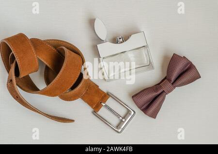 Bow tie, perfume and leather trouser belt. A gift to her husband, lover, father, boyfriend. View from above. Selective focus. Stock Photo