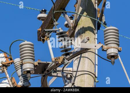 Overhead feeder power line on pole with fuse cutout switch for electrical utility distribution circuit overload and surge protection Stock Photo