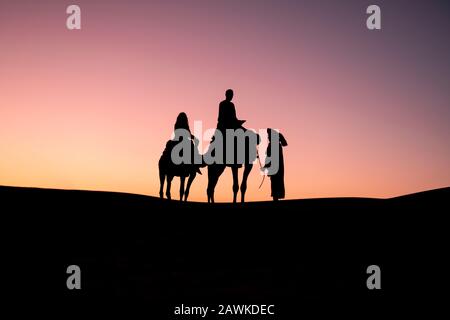 Travel background - camel rider in the Sahara desert of Morocco Stock Photo