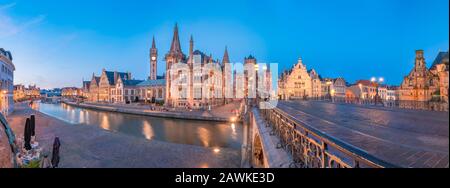 Panoramic view of the Graslei, quay in the promenade next to river Lys in Ghent, Belgium and St Michael's Bridge at dusk. Gent old town is famous for Stock Photo