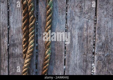 Yellow weathered ropes against rustic wooden boards Stock Photo