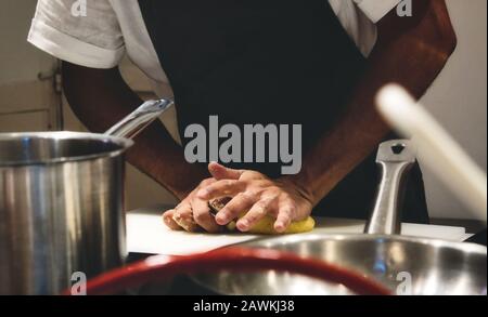 Close-up of chef's hands kneading dough on a kitchen worktop Stock Photo
