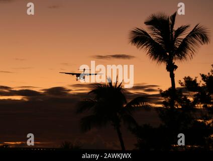 LIAT Airlines ATR turbo prop airliner coming in to land at Sint Maarten at Sunset Stock Photo