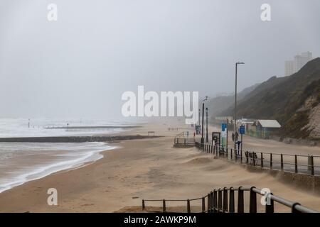 Boscombe, UK. Sunday 9th February 2020. Storm Ciara pounds the coast by Boscombe Pier in Bournemouth. A few brave venture on to the beach in very stormy weather. Sand is blown on to the promenade. Credit: Thomas Faull/Alamy Live News Stock Photo