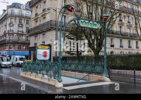 Entrance to the metropolitain - the parisian metro / subway system. The design of the railing around the gate & the sign above is called Art Nouveau. Stock Photo