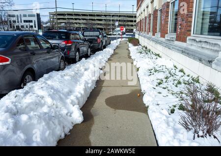 cars parked along building in the street after the snow storm in Summit Central New Jersey in winter Stock Photo