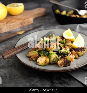 Roasted brussels sprouts portion. Healthy, homemade vegan food or loose weight. Dark background, square image Stock Photo