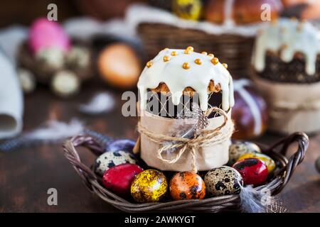 Holiday Easter cakes, hot cross buns and colorful painted eggs on rustic background Stock Photo