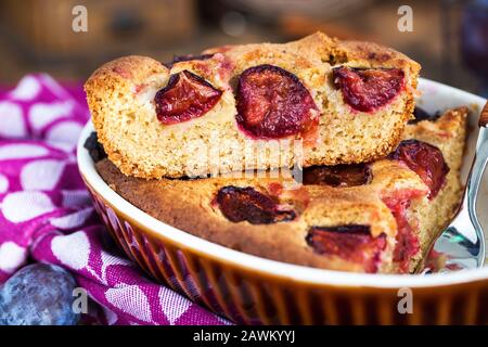 Fresh homemade dimply plum cake on rustic background Stock Photo